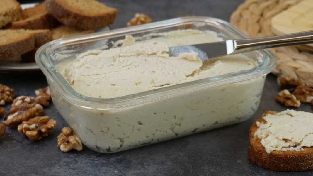 Ένα μπολ με βελούδινο σπιτικό πατέ κοτόπουλου, γαρνιρισμένο με φρέσκα μυρωδικά, δίπλα σε φρυγανισμένες φέτες ψωμιού.