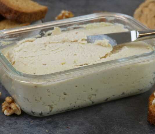 Ένα μπολ με βελούδινο σπιτικό πατέ κοτόπουλου, γαρνιρισμένο με φρέσκα μυρωδικά, δίπλα σε φρυγανισμένες φέτες ψωμιού.