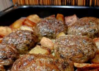 Ροδοκοκκινισμένοι τζιγεροσαρμάδες τυλιγμένοι σε μπόλια, τοποθετημένοι πάνω σε στρώση από προτηγανισμένες πατάτες μέσα στο ταψί.