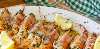 Ζουμερές γαρίδες Αργεντινής ψημένες στο φούρνο, περιχυμένες με σάλτσα ελαιολάδου, λεμονιού και φρέσκου μαϊντανού μέσα σε ένα κεραμικό σκεύος.