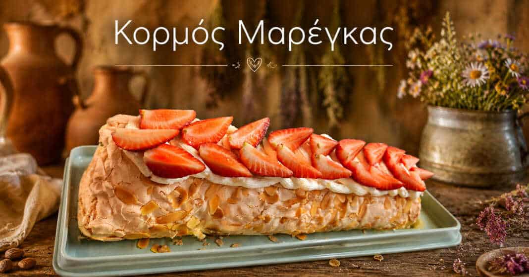 Λευκό, αέρινο ρολό μαρέγκας γεμισμένο με λευκή κρέμα και κατακόκκινο βύσσινο, στολισμένο με φρέσκα φρούτα.