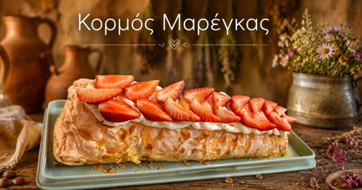 Λευκό, αέρινο ρολό μαρέγκας γεμισμένο με λευκή κρέμα και κατακόκκινο βύσσινο, στολισμένο με φρέσκα φρούτα.
