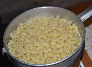 Αχνιστά μακαρόνια μέσα σε κατσαρόλα, ανακατεμένα με λιωμένο βούτυρο και τη γυαλιστερή σάλτσα από το νερό τους.