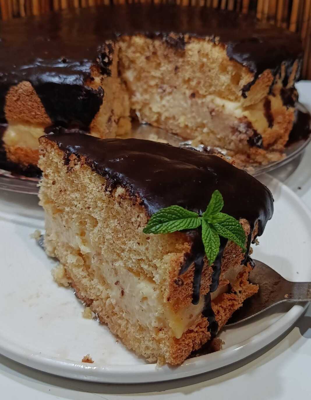 torta kok1 Εντυπωσιακή στρογγυλή τούρτα κωκ, λουσμένη με γυαλιστερό, πλούσιο γλάσο σοκολάτας κουβερτούρας, με εμφανείς τις στρώσεις από αφράτο παντεσπάνι και πλούσια λευκή κρέμα.