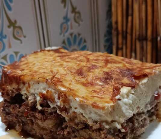 Παραδοσιακός σπιτικός μουσακάς Ένα μεγάλο κομμάτο παραδοσιακό μουσακά, με μια ροδοψημένη, χρυσή κρούστα μπεσαμέλ στην επιφάνεια και εμφανείς τις στρώσεις λαχανικών και κιμά