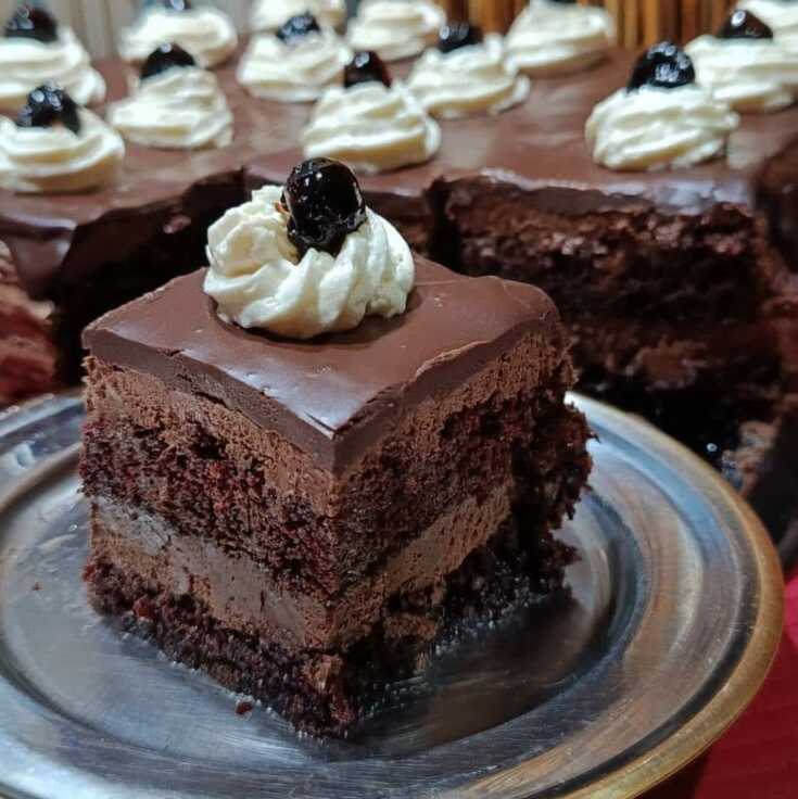 Τούρτα Black Forest με σοκολατένιο παντεσπάνι, κρέμα, σαντιγί, γκανάζ σοκολάτας και βύσσινο στην επιφάνεια.