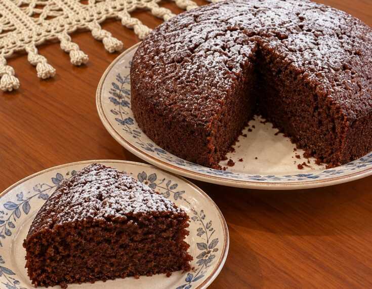 Σοκολατένιο κέικ σιμιγδαλιού με σκούρα αφράτη ψίχα και άχνη ζάχαρη στην επιφάνεια