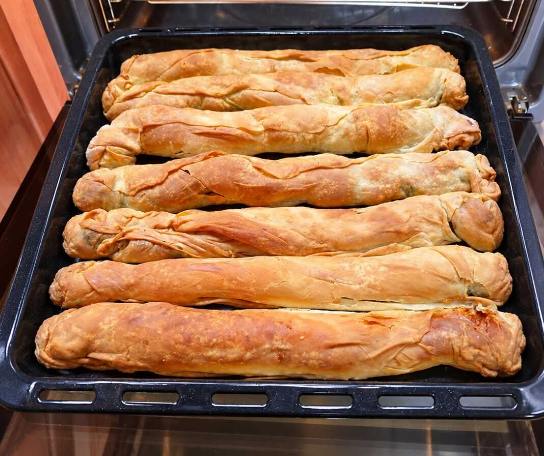 Μακρόστενες χρυσαφένιες σπανακοτυρόπιτες μπαστούνια με χειροποίητο φύλλο και γέμιση από σπανάκι και φέτα