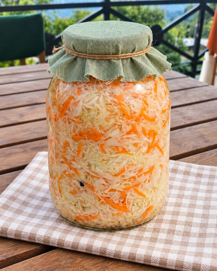 Τραγανό λευκό λάχανο τουρσί με λεπτές λωρίδες καρότου μέσα σε γυάλινο βάζο